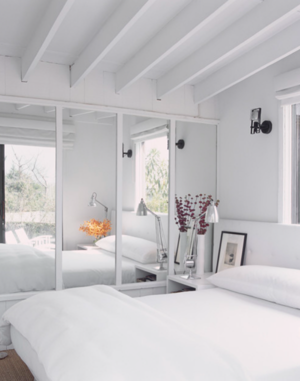 Kamar dengan cermin dinding besar yang menciptakan ilusi ruang yang luas